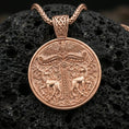 Load image into Gallery viewer, Rose gold plated Viking deer medallion pendant necklace on textured volcanic rock, centered studio-style close-up showcasing soft rosy glow and intricate Norse-inspired scroll-and-stag detailing.
