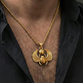Load image into Gallery viewer, Gold plated winged scarab beetle pendant necklace worn on the neck, lifestyle photo featuring warm tone finish and strong statement Egyptian talisman presence.