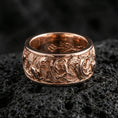 Load image into Gallery viewer, Rose gold plated koi fish band ring on textured volcanic rock, centered studio-style close-up showcasing soft rosy glow and intricate koi-and-wave engraving with a refined finish.