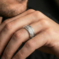 Load image into Gallery viewer, Polished silver Veni Vidi Vici spinner ring worn on a finger, clean lifestyle wear shot capturing bright shine and the engraved lettering in natural light.