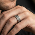 Load image into Gallery viewer, Oxidized Veni Vidi Vici spinner ring worn on a finger, lifestyle framing showing realistic scale and bold vintage contrast in a natural hand pose.