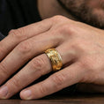 Load image into Gallery viewer, Gold plated wolf head band ring worn on a finger, lifestyle photo featuring warm tone finish and strong statement band presence.