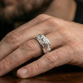 Load image into Gallery viewer, Polished silver twin lion band ring worn on a finger, clean lifestyle wear shot capturing bright shine and the detailed lion relief in natural light.