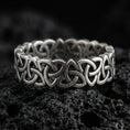 Load image into Gallery viewer, Oxidized Celtic triquetra chain-link ring on textured volcanic rock, centered close-up highlighting the interwoven Trinity knot links and deep antique shadowed contrast.