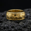 Load image into Gallery viewer, Gold plated hieroglyph band ring on volcanic stone, premium close-up showing warm gold tone over the carved Egyptian hieroglyph pattern.