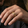 Load image into Gallery viewer, Gold plated geometric weave band ring worn on a finger, lifestyle shot emphasizing luxurious gold tone and the structured lattice weave for a statement look.
