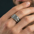 Load image into Gallery viewer, Polished silver mythic faces cuff band ring worn on a finger, lifestyle shot focusing on bright reflective finish and the detailed portrait band design.