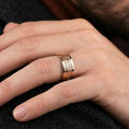 Load image into Gallery viewer, Rose gold plated Greek key spinner ring worn on a finger, lifestyle image emphasizing warm rose tone, clean lines, and the refined rotating band design.