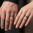 Load image into Gallery viewer, Oxidized sterling silver hammered texture band ring worn on a finger, lifestyle wear image focusing on the bold faceted texture and dark contrast.