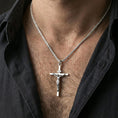 Load image into Gallery viewer, Polished silver crucifix pendant worn on the neck, lifestyle photo highlighting clean shine, clear figure details, and modern minimal presence.