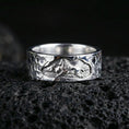Load image into Gallery viewer, Polished silver lion band ring on volcanic stone, crisp macro shot emphasizing bright edges, smooth interior, and high-definition lion engraving.