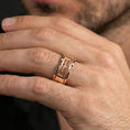 Load image into Gallery viewer, Rose gold plated sci-fi band ring worn on the finger, lifestyle image showing elegant rose tone, sculpted mechanical details, and a premium contemporary aesthetic.