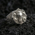 Load image into Gallery viewer, Polished silver skull signet ring with intricate Celtic knotwork on porous volcanic stone, close-up highlighting sharp edges and clean reflective finish
