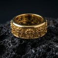 Load image into Gallery viewer, Gothic cross spinner ring on black volcanic stone, shown in a gold plated finish with warm shine emphasizing the gothic cross motifs and dotted texture.