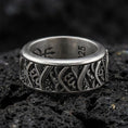 Load image into Gallery viewer, Rotating wave spinner ring on black volcanic stone, photographed in oxidized sterling silver with darkened recesses emphasizing the flowing nautical wave pattern.