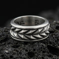 Load image into Gallery viewer, Mechanic style spinning fidget band ring on black volcanic stone, photographed in oxidized sterling silver with darkened grooves that sharpen the faceted pyramid texture.
