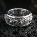 Load image into Gallery viewer, Koi fish sterling silver band ring on black volcanic stone, photographed in a polished silver look with clean highlights across the koi and wave engraving.