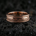 Load image into Gallery viewer, Sterling silver wave band ring on black volcanic stone, presented in a rose gold plated finish with a softer warm tone that enhances the wave relief and rope-edge texture.