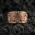 Load image into Gallery viewer, Sterling silver Masonic square and compass band ring on black volcanic stone, presented in a rose gold plated finish with a softer warm tone that enhances the emblem depth and ornamental engraving.