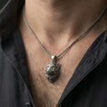 Load image into Gallery viewer, Oxidized boar head pendant necklace worn on the neck, lifestyle close-up showing rugged animal symbolism and masculine statement style