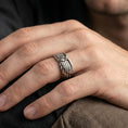Load image into Gallery viewer, Angel wing sterling silver band ring worn on a finger, oxidized finish creating a bold vintage look and clear feather definition.