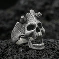 Load image into Gallery viewer, Oxidized sterling silver openwork skull ring on black volcanic rock, macro close-up showing deep patina and woodgrain-style texture lines