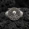 Load image into Gallery viewer, Polished silver Norse warrior signet ring on porous volcanic stone, close-up highlighting crisp rune-inspired linework, helmet skull and axe detailing