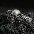 Load image into Gallery viewer, Oxidized sterling silver skull ring wrapped in thorny vine links on black volcanic rock, macro close-up emphasizing darkened recesses and gothic texture