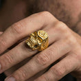 Load image into Gallery viewer, Gold plated skull ring with Masonic square and compass “G” emblem worn on a finger, lifestyle image emphasizing warm tone and bold statement style