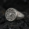 Load image into Gallery viewer, Oxidized sterling silver spiral sun signet ring with swirling Celtic-style face and geometric side panels, macro shot on black volcanic rock