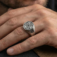 Load image into Gallery viewer, Oxidized Celtic triskelion octagon signet ring worn on a finger, close-up lifestyle photo highlighting the engraved swirl symbol