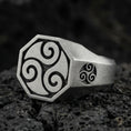 Load image into Gallery viewer, Oxidized sterling silver octagon signet ring with Celtic triskelion swirl engraving and matching side emblem, macro photo on black volcanic rock