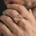 Load image into Gallery viewer, Rose gold plated Saint Michael ring on a finger, lifestyle photo focusing on the relief depth, Roman numerals, and engraved side text