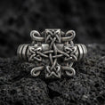 Load image into Gallery viewer, Oxidized sterling silver Celtic knot cross ring with interlaced Trinity-style weave and darkened recessed texture, macro product photo on black volcanic rock