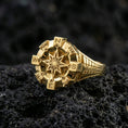 Load image into Gallery viewer, Gold plated compass ring with bold eight-point star centerpiece and directional initials around the bezel, product-only macro image on black volcanic rock