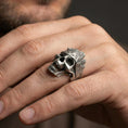 Load image into Gallery viewer, Oxidized woodgrain skull ring worn on a finger, lifestyle close-up highlighting carved bark texture and gothic biker look