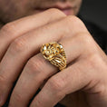 Load image into Gallery viewer, Gold plated biker skull ring worn on a finger, lifestyle close-up emphasizing the wing accents and bold motorbike motif