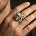 Load image into Gallery viewer, Polished silver horned skull ring on the finger, wearable close-up focusing on the sculpted skull and horn texture