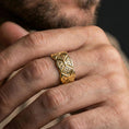 Load image into Gallery viewer, Gold plated engraved ornament band worn on finger, raised diamond pattern with scrollwork accents, premium lifestyle jewelry photo.