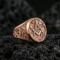 Load image into Gallery viewer, Rose gold plated Freemason square and compass ring with “G” symbol and detailed scroll engraving, macro photo on black volcanic rock