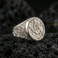 Load image into Gallery viewer, Polished silver Freemason ring with raised square and compass symbol and “G” letter, macro on volcanic stone background