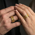 Load image into Gallery viewer, Gold plated railway track band worn on finger, detailed industrial texture with riveted edges, premium lifestyle jewelry photo.