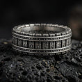 Load image into Gallery viewer, Oxidized sterling silver railway track band ring on dark volcanic rock, industrial rivet lines and train rail texture, premium macro product shot.