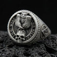 Load image into Gallery viewer, Oxidized sterling silver owl signet ring with skull detail and “THE WISE ARE SILENT” text, on black volcanic rock