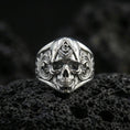 Load image into Gallery viewer, Polished silver Freemason skull signet ring featuring compass and letter G on the forehead with ornate side engravings, macro on volcanic stone