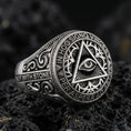 Load image into Gallery viewer, Oxidized sterling silver all-seeing eye triangle ring with Latin inscription and engraved scrollwork, macro on black volcanic rock