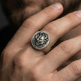 Load image into Gallery viewer, Oxidized oni demon signet ring worn on a finger, close-up lifestyle shot highlighting the engraved Japanese mask and floral relief