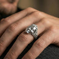 Load image into Gallery viewer, Polished silver finish third eye face ring on the finger, macro lifestyle photo emphasizing the smooth face relief and ornate engraved band