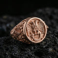 Load image into Gallery viewer, Sterling silver Masonic ring with a rose gold plated finish, detailed double-headed eagle crest and Masonic side symbol engraving, close-up on volcanic rock