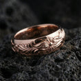 Load image into Gallery viewer, Rose gold plated sterling silver floral pattern band on volcanic stone, ornate flower motif with flowing scroll engraving, minimal high-end close-up.